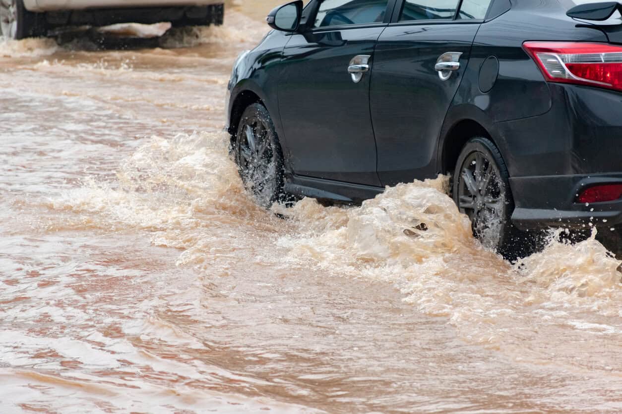 Car wheel in muddy rain and floodwater