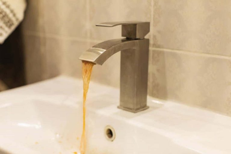 Dirty rusty water flows from faucet.
