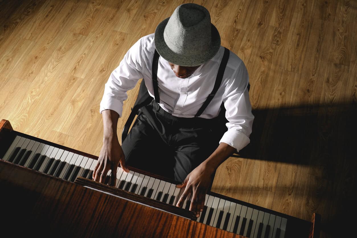 African-American man playing piano indoors, above view. Talented musician