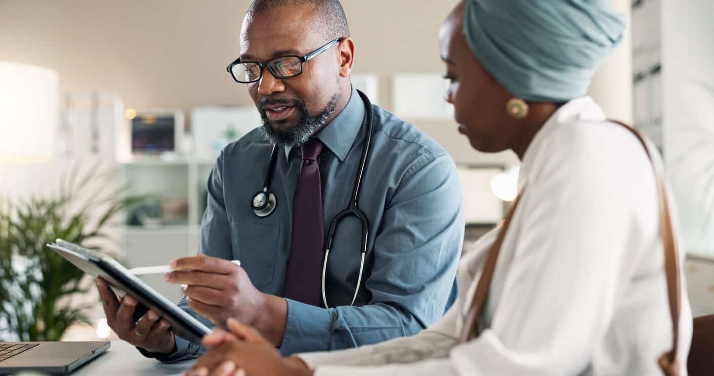Tablet, conversation and black woman with doctor in hospital for medical diagnosis or wellness advice. Discussion, digital technology and female patient with healthcare worker for checkup in clinic.