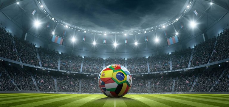 Football with international flags in the stadium at night.