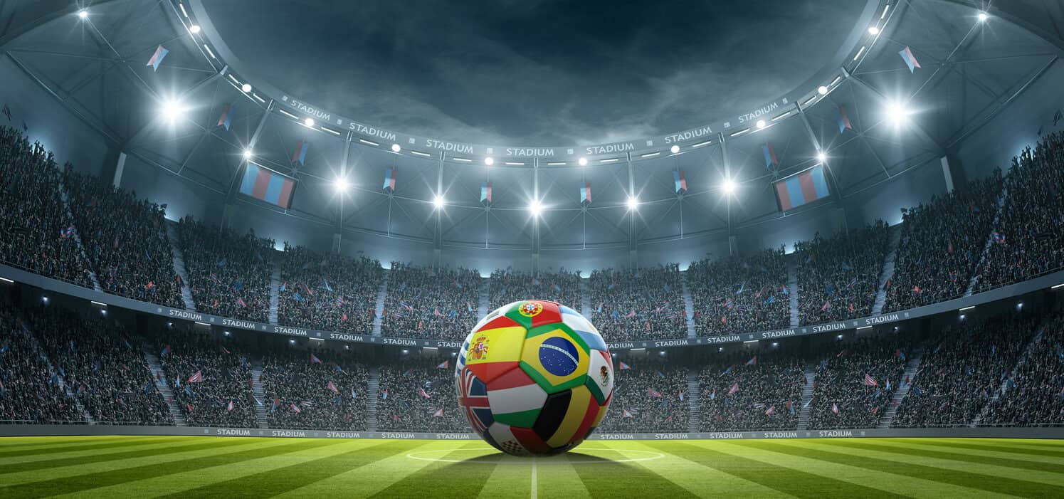 Football with international flags in the stadium at night.