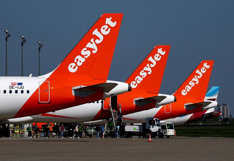 FILE PHOTO: Passengers board an easyJet aircraft at the Berlin Brandenburg Airport in Schoenefeld