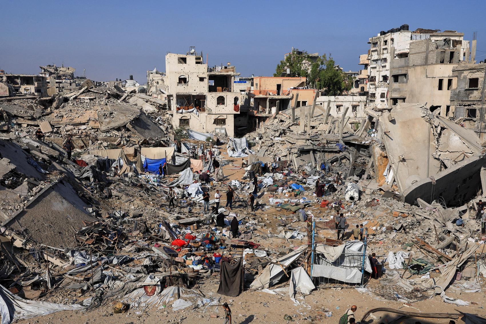 Palestinians inspect the site of Wednesday's Israeli strike on a house whose residents were pre-warned by the Israeli military to evacuate, in Gaza City