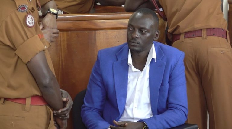 202503Eron-Kiiza-sorrounded-by-prison-officers