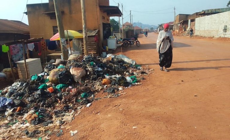 202608Woman-walks-past-garbage-in-Bwaise